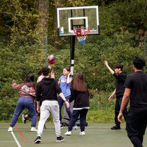 Students reaching to the basketball goal