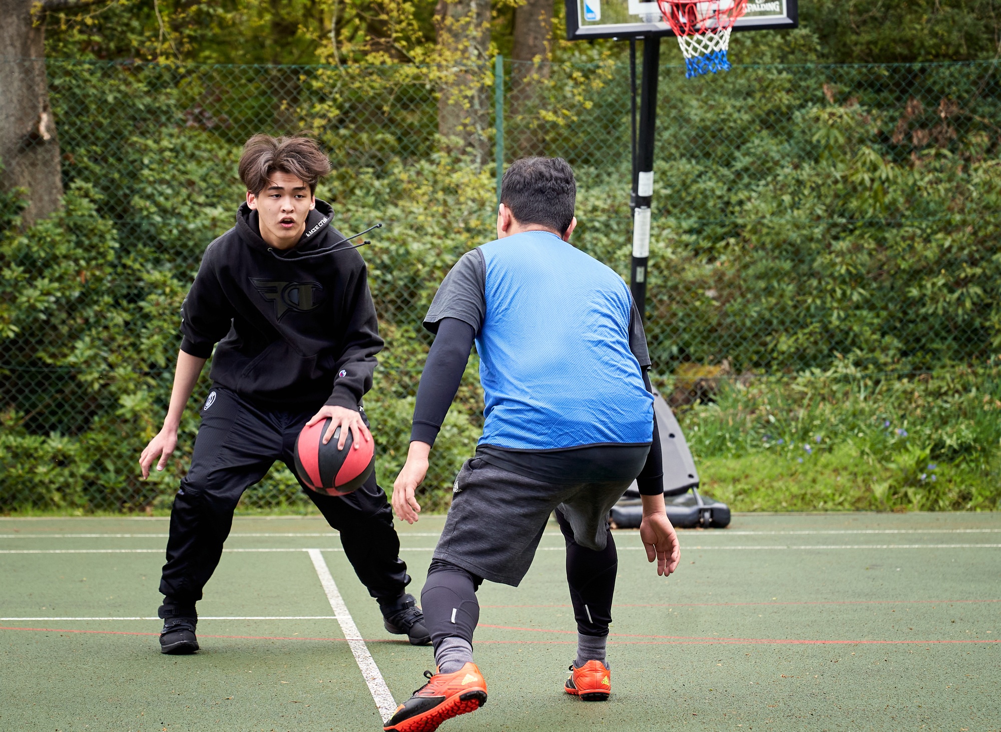 2 students playing basketball together