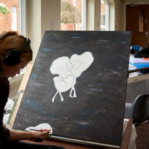 girl painting in a class room