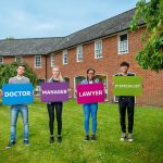 Job titles held up with cardboard that students are holding