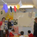 three teachers standing up at the front of a class