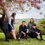 Student talking as they sat against a tree