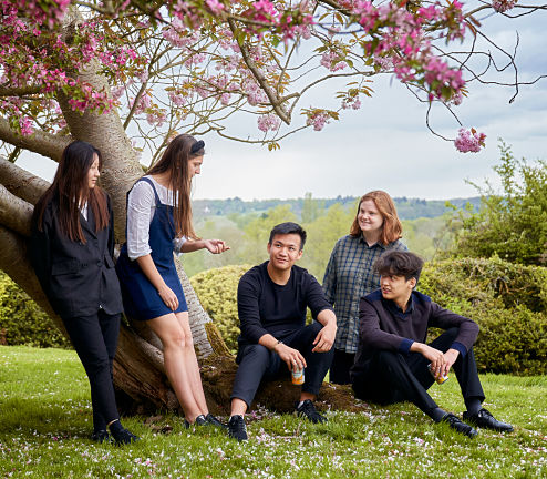 Student talking as they sat against a tree