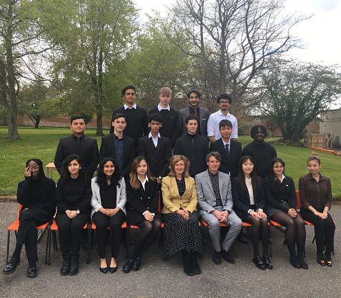 A range of students and teachers sat in a row