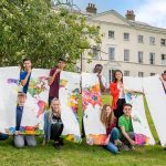 children holding up a cut up poster